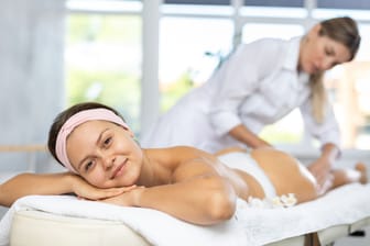 Young woman relaxing during thigh and butt massage in spa salon