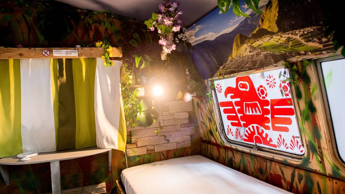 Ein Wohnwagen, der thematisch zum Reiseziel Peru gestaltet wurde, steht im Indoor-Hostel-Camp.