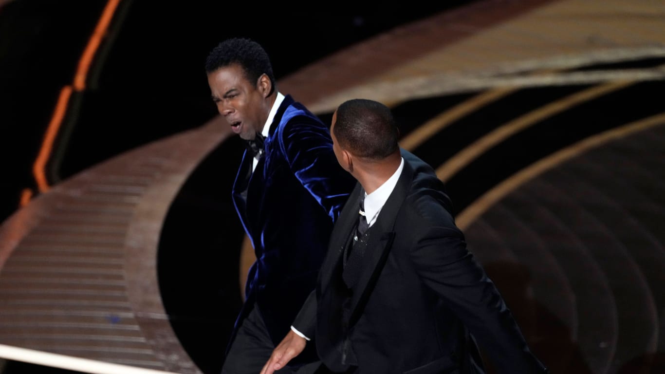 Will Smith schlägt Chris Rock 2022 auf der Oscar-Bühne.