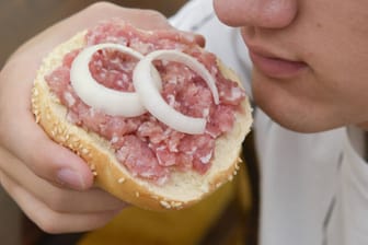 Eine Person isst ein Mettbrötchen (Symbolbild): Die kleine Leckerei ist schnell gemacht und hat viele Fans in Deutschland.