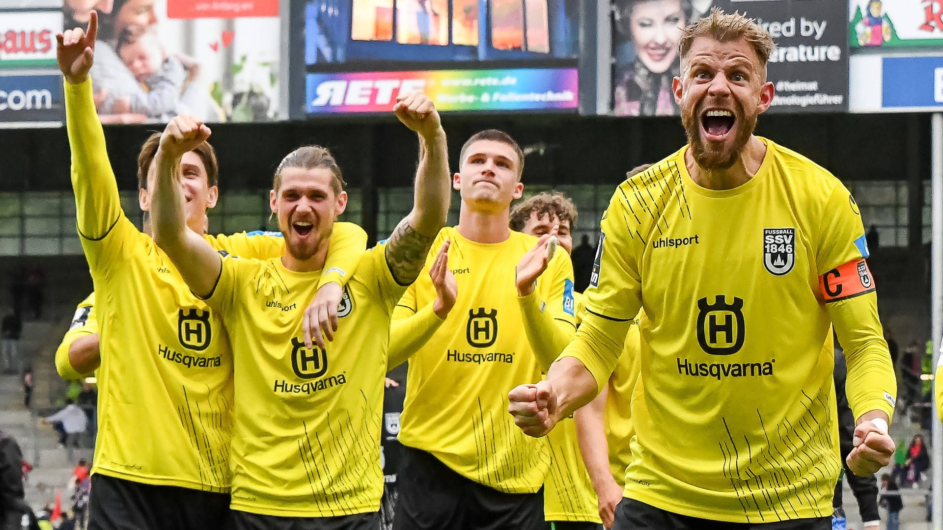 Ulms Spieler jubeln vor der Kurve nach dem Sieg in Freiburg.