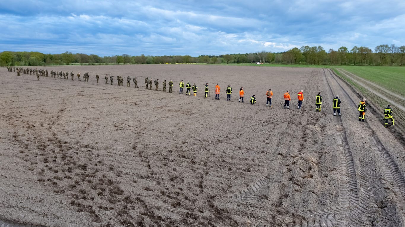 Bundeswehrsoldaten und Einsatzkräfte von Feuerwehr und Polizei auf einem Feld bei Estorf-Gräpel: Die Suche am Sonntag dauerte wegen des schwierigen Geländes länger als geplant.