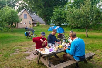 Touristen essen im Nationalpark Hüttener Berge: Hier ist ein Kurzurlaub mit Bergpanorama und Meeresbrise möglich.