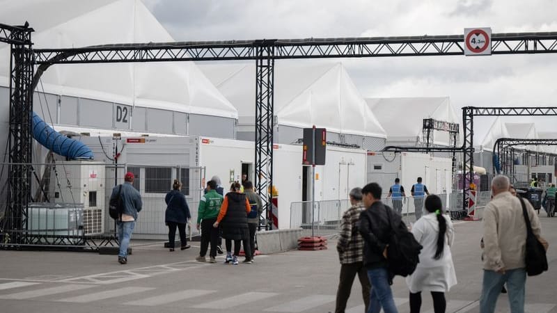 Bewohner und Mitarbeiter gehen im Ankunftszentrum am ehemaligen Flughafen Tegel in Richtung der Leichtbauhallen.