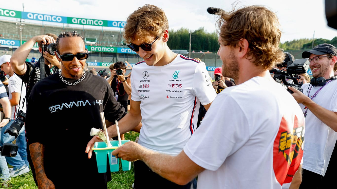 Engagiert: Vettel zeigt den Mercedes-Piloten Russell und Hamilton (v. r.) sein Imker-Projekt am Rande des Japan-Grand-Prix im vergangenen Jahr.