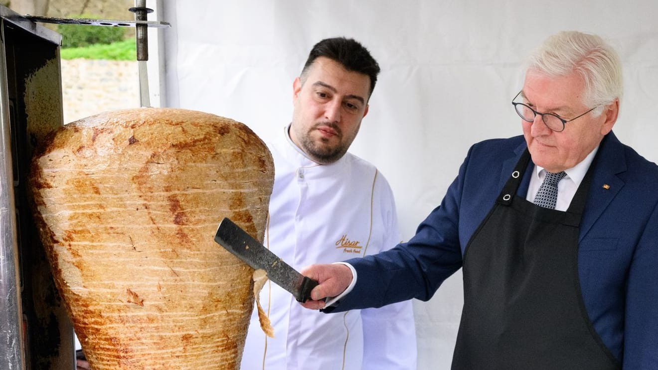 Arif Keles überwacht, wie Bundespräsident Frank-Walter Steinmeier den Dönerspieß anschneidet.