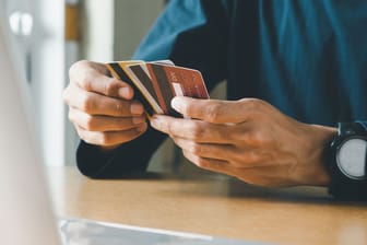 Mann hält mehrere Kreditkarten in der Hand
