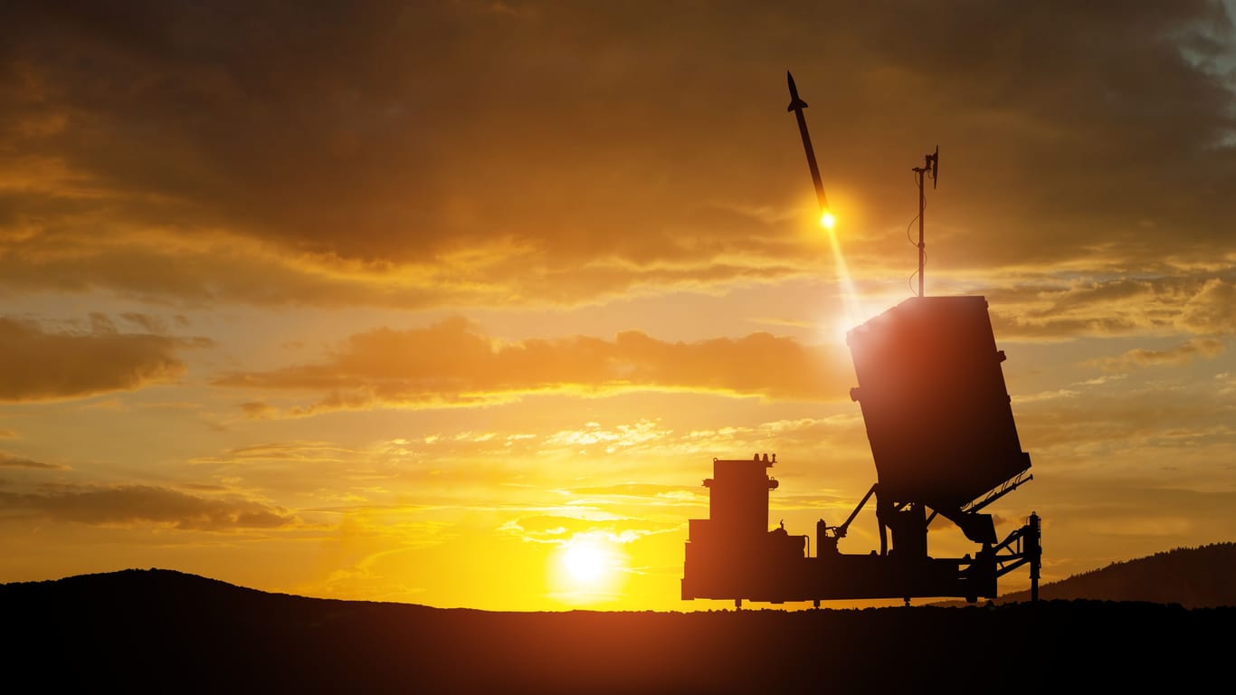Israel's Iron Dome air defense missile launches. The missiles are aimed at the sky at sunset.