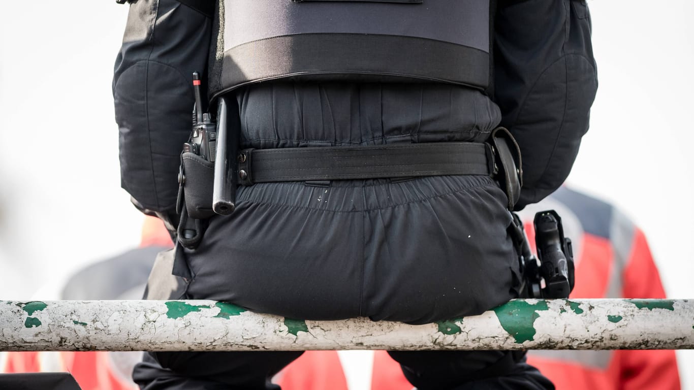 Ein Polizist sitzt auf einer Metallstange in einem Stadion (Symbolfoto): Die Ermittler aus Bremen halten sich zurzeit bedeckt und nennen keine weiteren Details.
