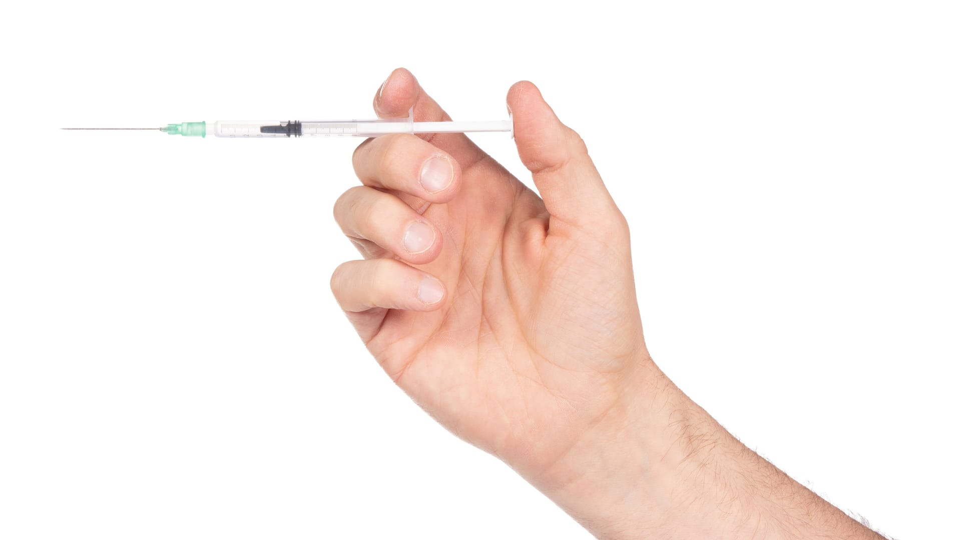 New syringe in adult hand on white background New syringe in adult hand on white background