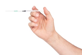 New syringe in adult hand on white background
