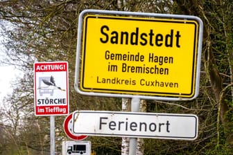 "Achtung! Störche im Tiefflug" steht auf einem Schild neben dem Ortsschild von Sandstedt im Landkreis Cuxhaven.