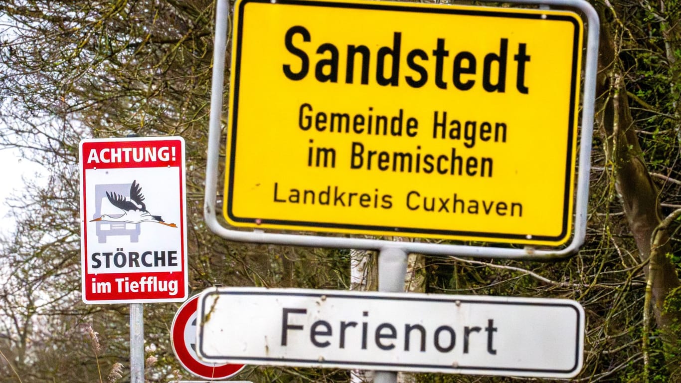 "Achtung! Störche im Tiefflug" steht auf einem Schild neben dem Ortsschild von Sandstedt im Landkreis Cuxhaven.
