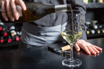 Eine Person gießt Wein in ein Weinglas (Symbolbild): Die beliebte "Klinkerbar" eröffnet bald an ihrem neuen Standort auf St. Pauli.