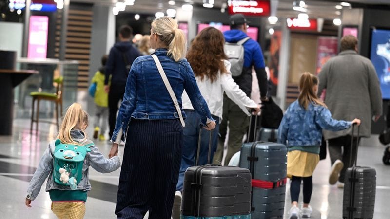 Reisende schieben ihre Koffer am Flughafen Düsseldorf zur Gepäckaufgabe (Archivbild): Hier und am Flughafen Köln/ Bonn ist zum Ferienende besonders viel los.