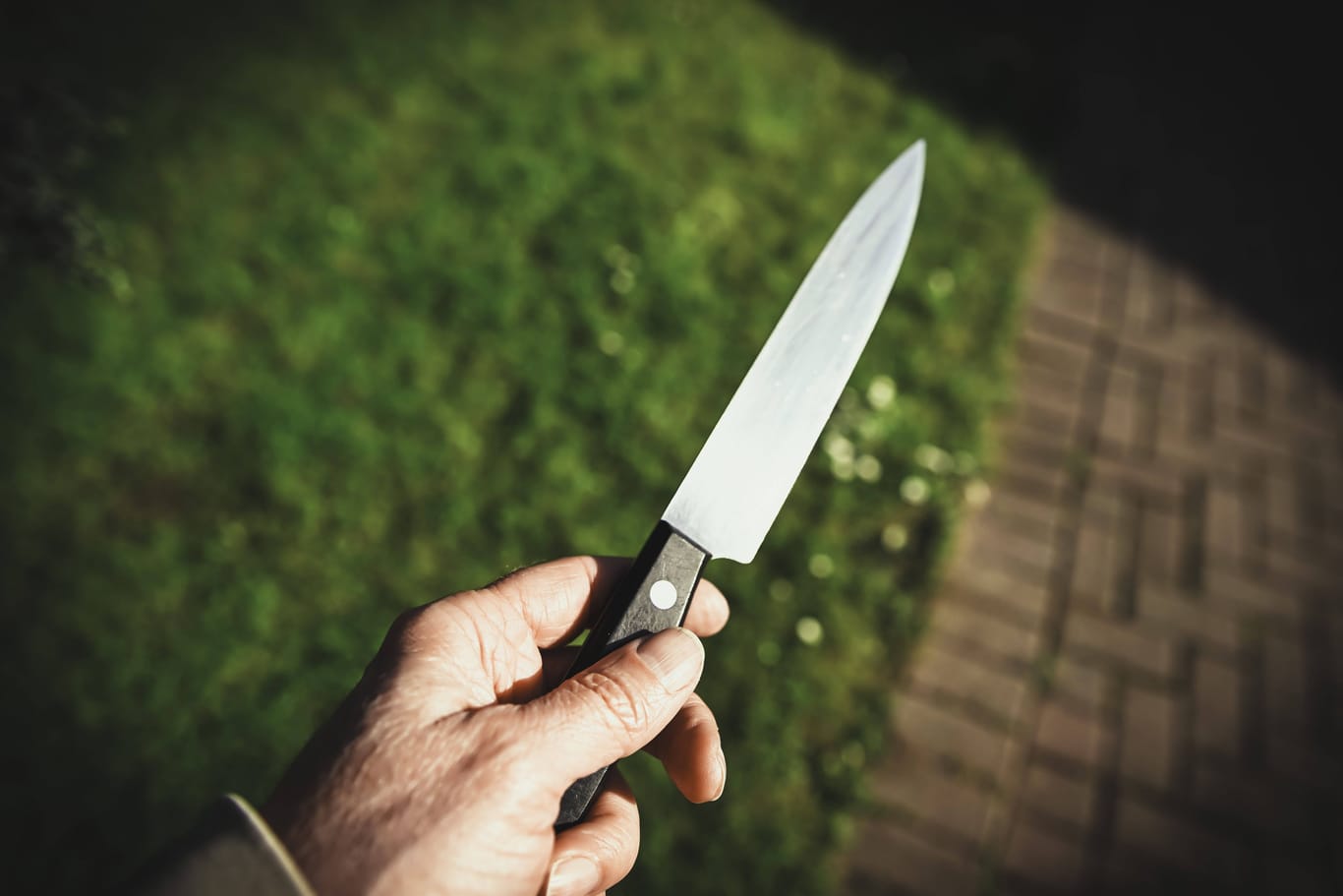Ein Mann hält ein Messer in der Hand (Symbolbild): In Köln ist ein 59-Jähriger mit Stichverletzungen gefunden worden.
