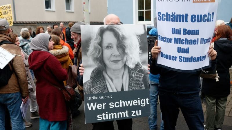 Teilnehmer einer Demonstration bekunden mit Schildern und Reden vor dem Arbeitsgericht in Bonn ihre Solidarität mit der Politologin Ulrike Guérot.