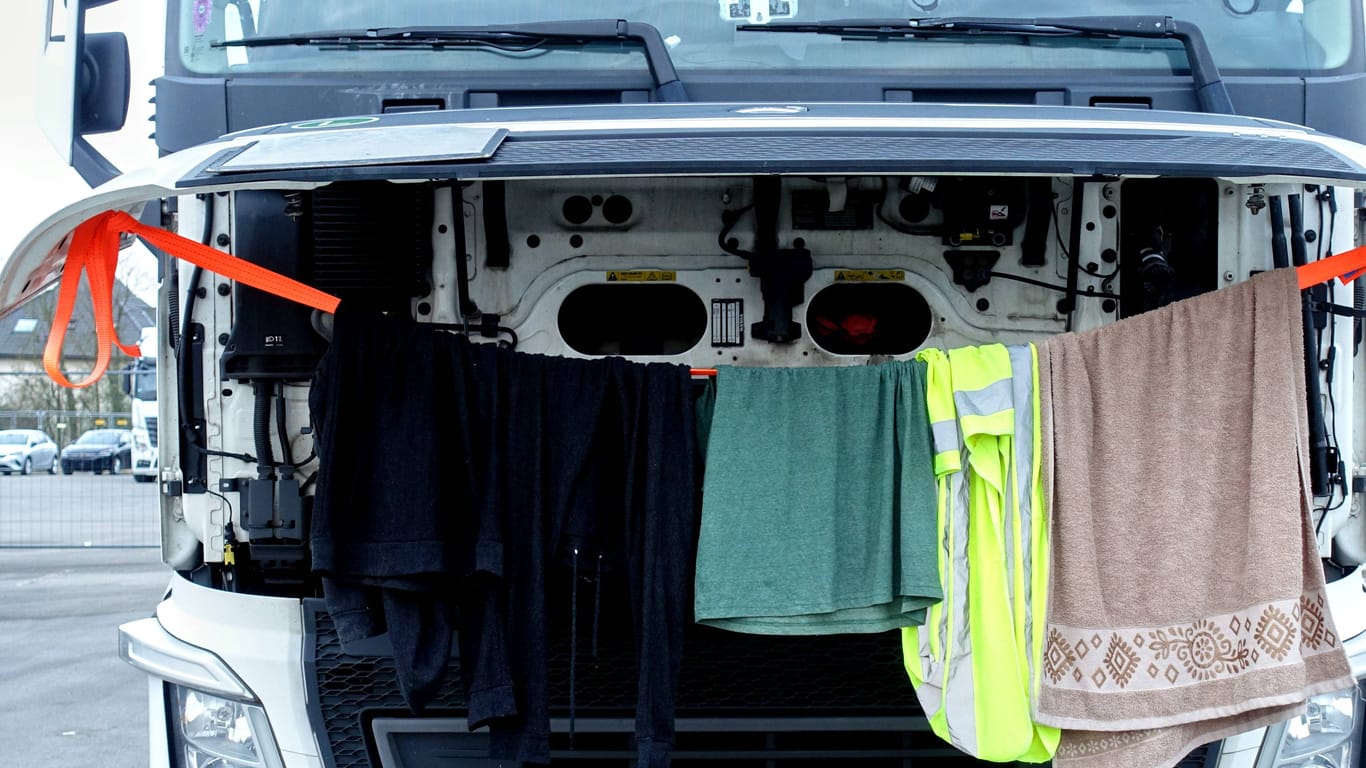 LKW-Fahrer trocknet seine Wäsche bei offener Motorhaube (Symbolbild): 23.000 LKW-Parkplätze fehlen in Deutschland.