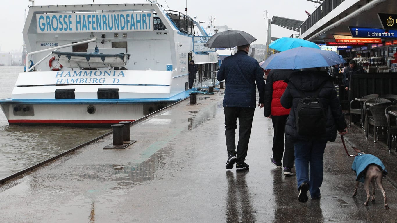 Spaziergänger im Regen an den Landungsbrücken (Archivbild): Tief "Patricia" bringt reichlich Wasser von oben nach Hamburg.