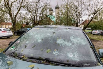 Vom Hagel zerstörte Windschutzscheibe eines Autos: Immer wieder trifft Extremwetter auch Deutschland.