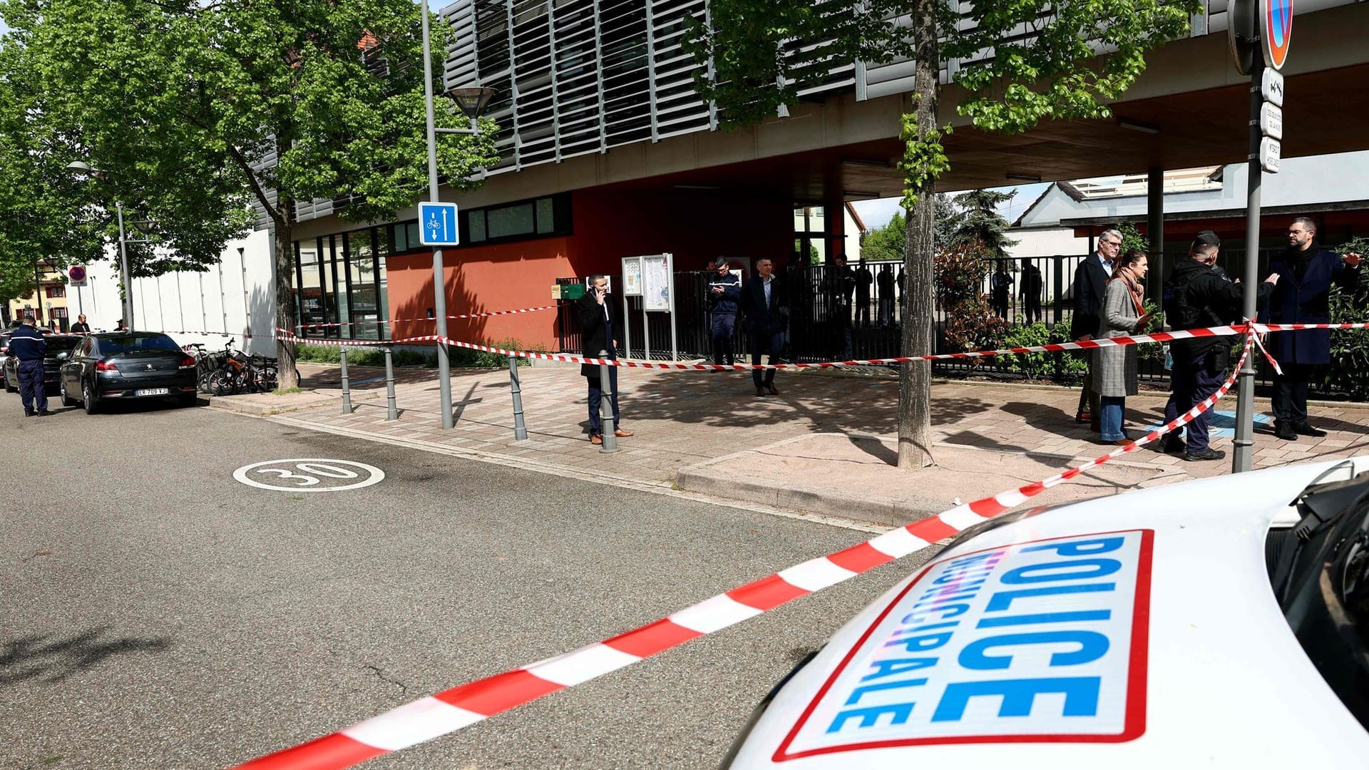 Die Polizei untersucht die Umgebung einer Schule, nachdem zwei Grundschülerinnen bei einem Messerangriff vor der Schule leicht verletzt worden waren.