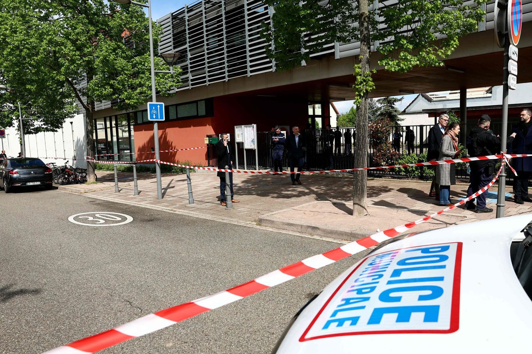 Die Polizei untersucht die Umgebung einer Schule, nachdem zwei Grundschülerinnen bei einem Messerangriff vor der Schule leicht verletzt worden waren.