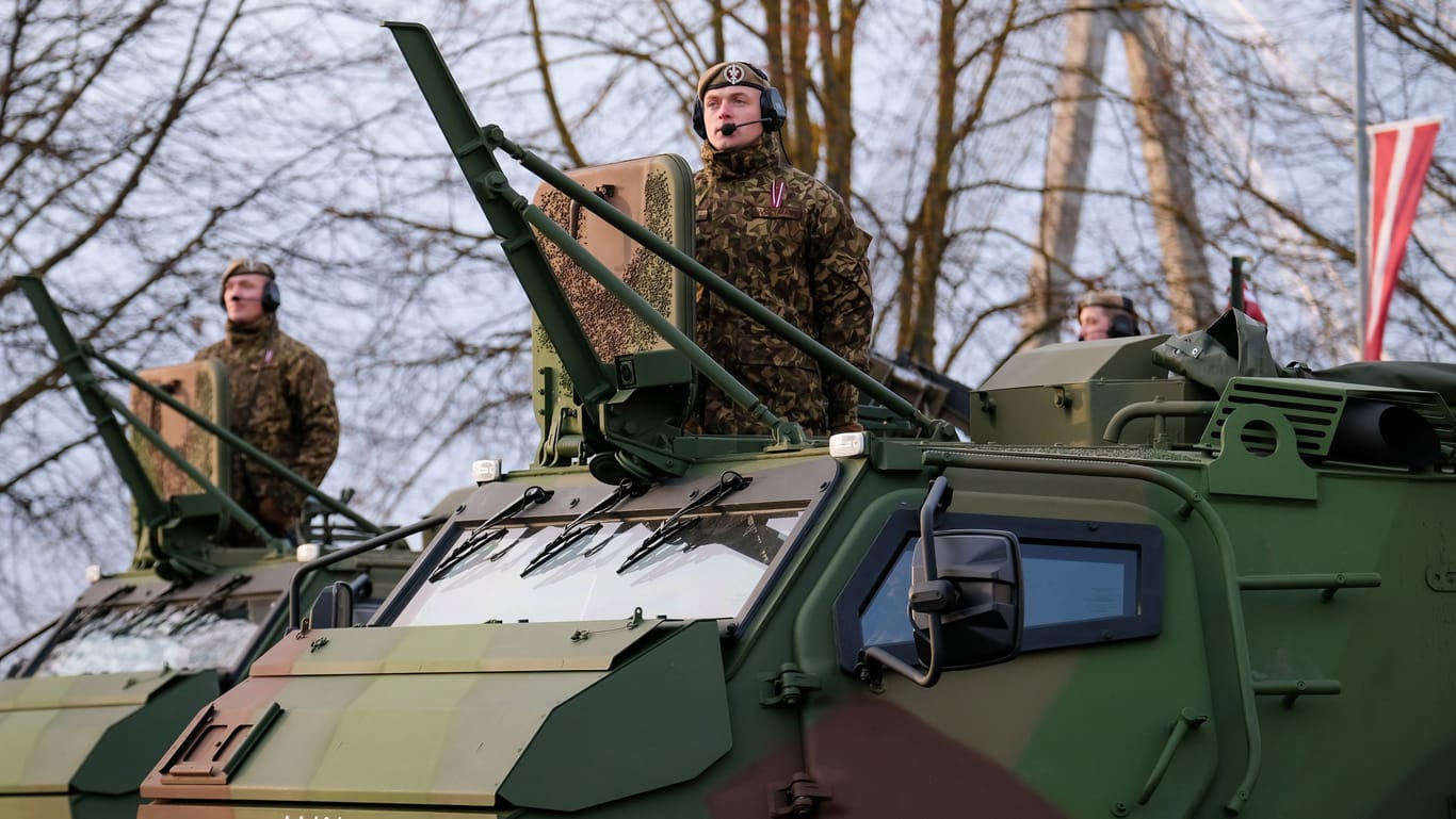 Riga, Latvia - November 18, 2022: Finnish made armoured personnel carrier Patria 6x6 of army of Latvia in a parade in the capital of Latvia, Riga. Defocused