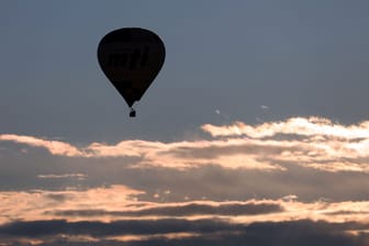 Ein Heißluftballon gleitet am frühen Morgen über das Alpenvorland (Archivbild): Am Wochenende lädt das Wetter zu Outdoor-Aktivitäten ein.