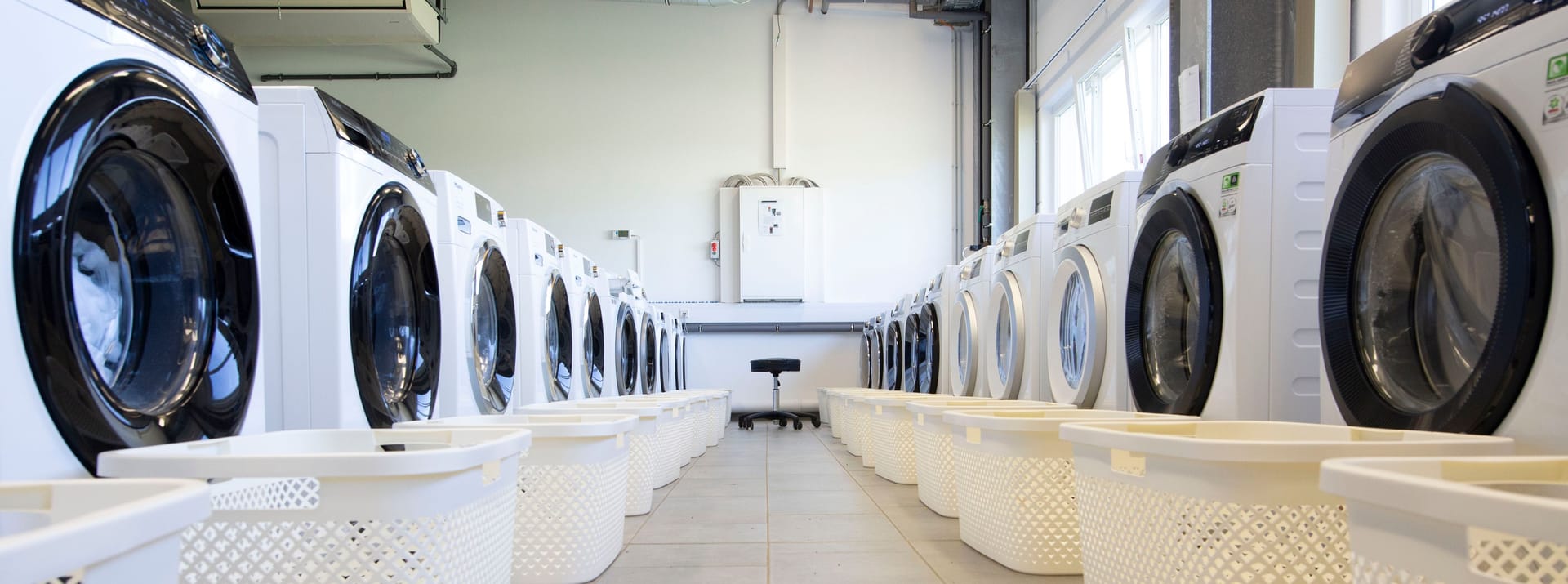 Waschmaschinen im Dauertest: Mit 1.200 Waschgängen je Maschine werden zehn Jahre Nutzungsdauer simuliert. Im Schichtbetrieb sind deshalb mehrere Mitarbeitende durchgehend mit waschen beschäftigt.
