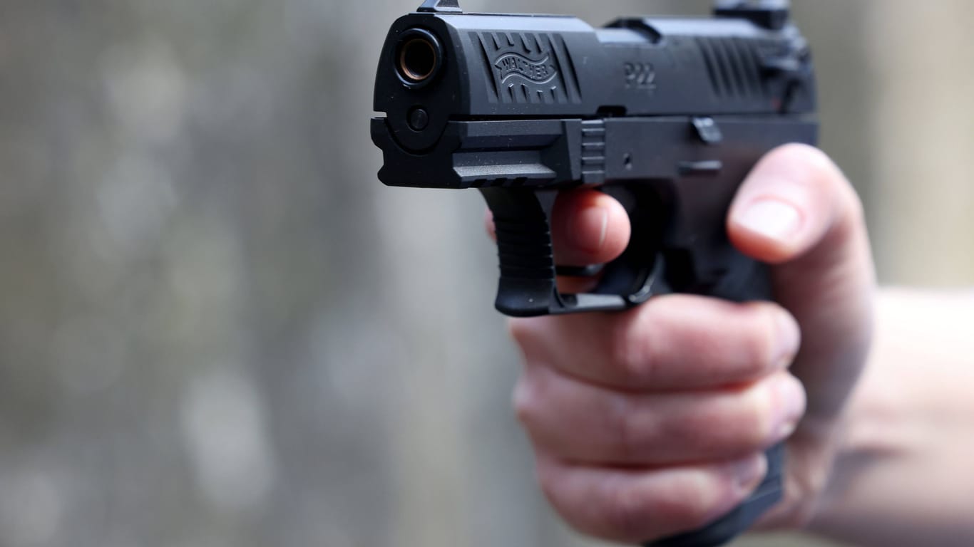 Ein Mann hält eine Pistole in der Hand (Symbolbild): Der Täter konnte unerkannt flüchten.