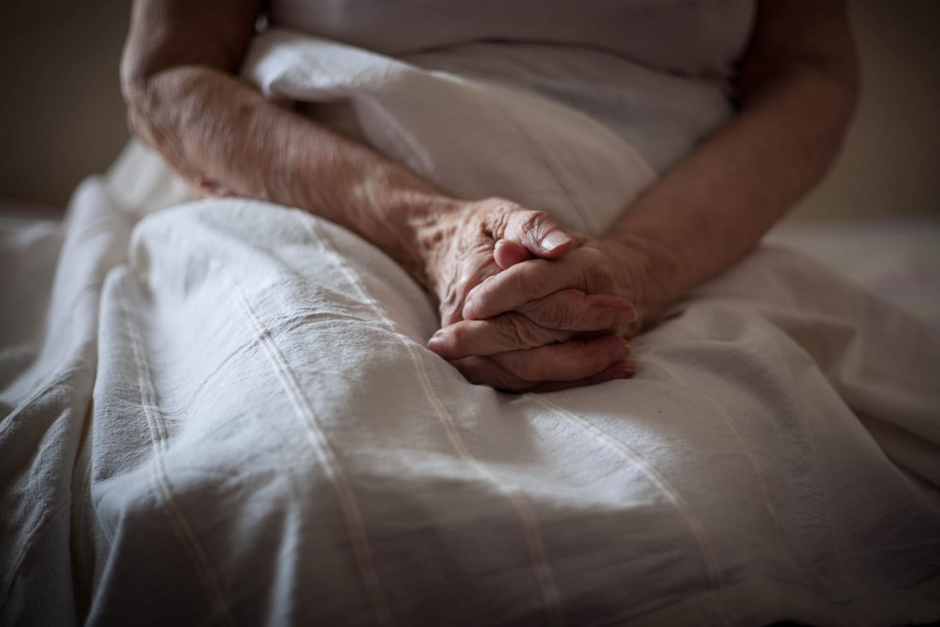 Eine ältere Person in einem Bett (Symbolbild): Ein 84-jähriger Rentner muss das Mietshaus, in dem er seit seiner Geburt lebt, verlassen