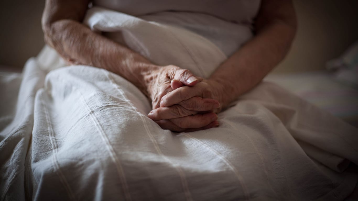 Eine ältere Person in einem Bett (Symbolbild): Ein 84-jähriger Rentner muss das Mietshaus, in dem er seit seiner Geburt lebt, verlassen