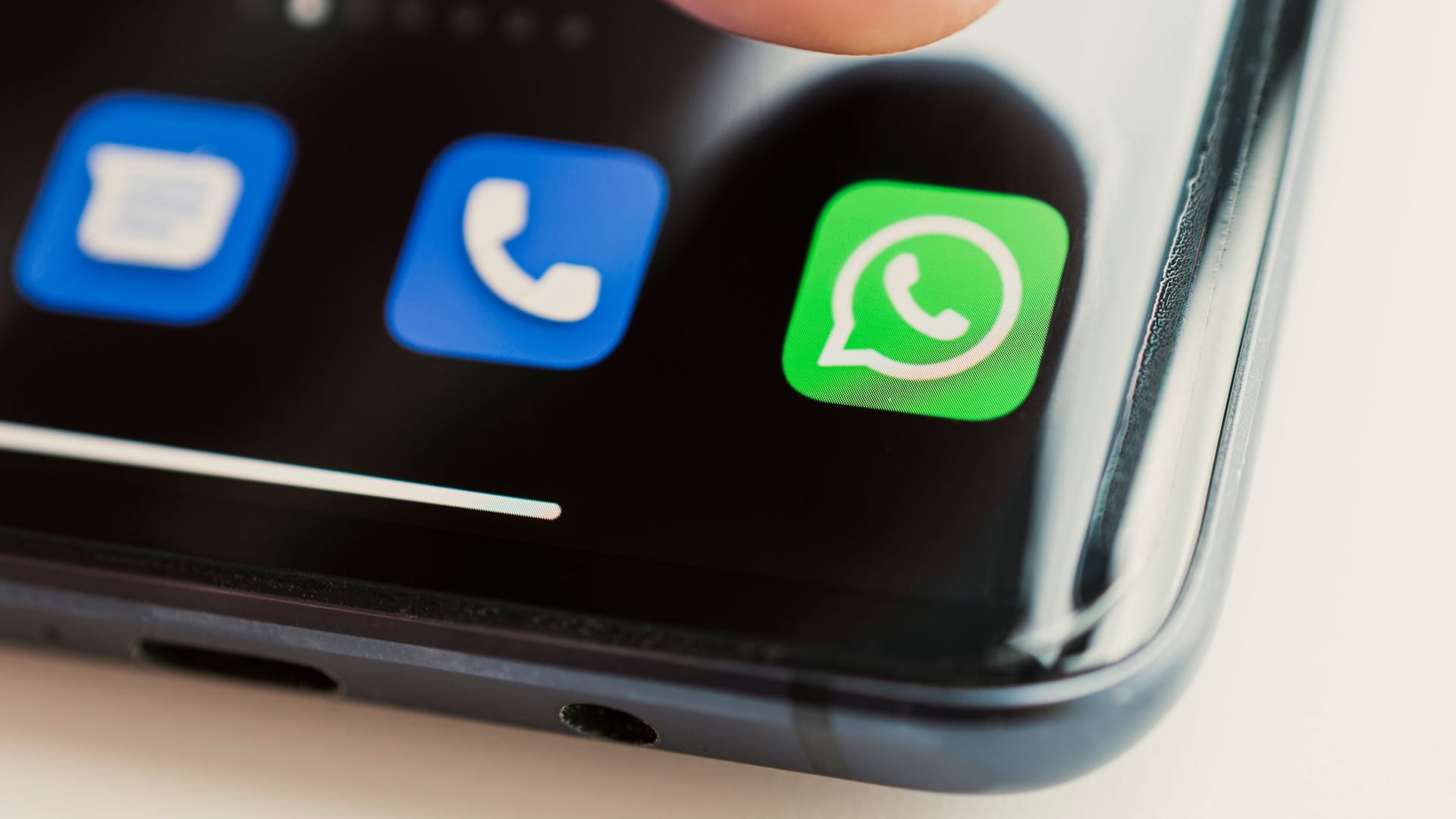 Icon of the app on the screen of a black smartphone. whatsapp