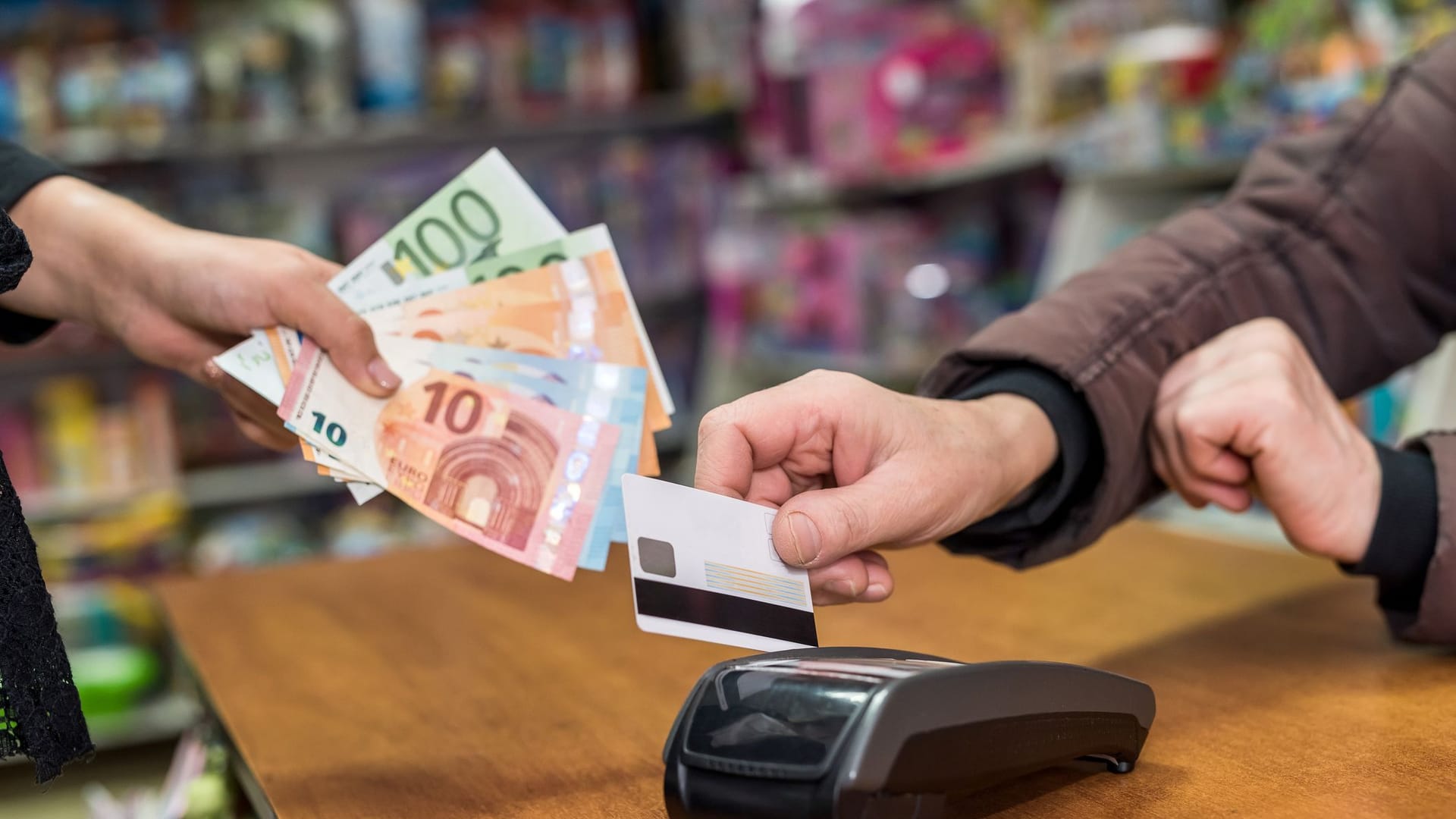 Bargeld abheben an einer Kasse im Supermarkt