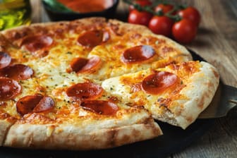 Eine Pizza wird auf einem Teller serviert (Symbolbild): Zwei Münchner Restaurant schafften es unter die besten Zehn in ganz Bayern.