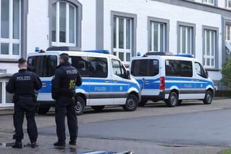 Polizisten stehen vor einem Gebäude, das durchsucht wird: Die Großrazzia fand in acht Bundesländern statt.