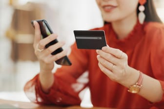 Frau bezahlt ihren Online-Einkauf mit einer Kreditkarte