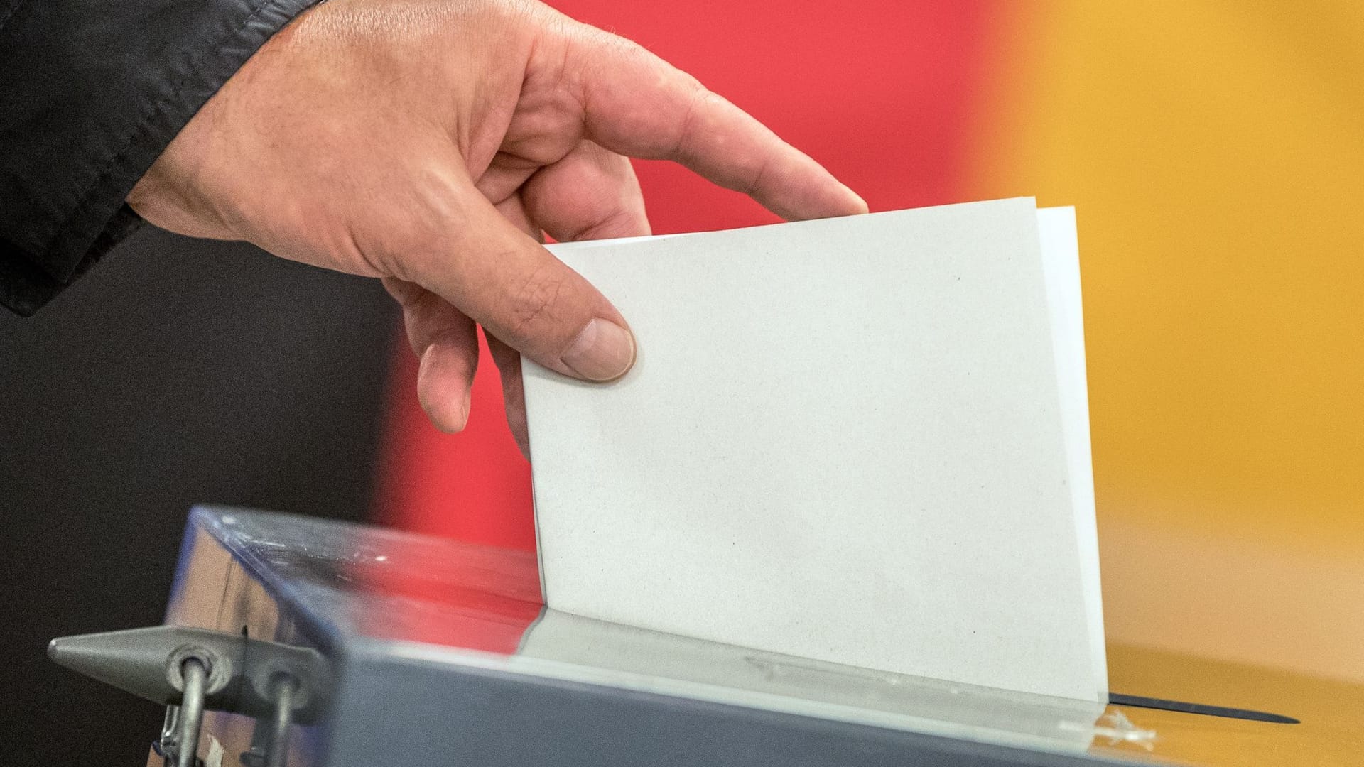 Ein Wähler wirft seinen Stimmzettel in eine Wahlurne (Symbolfoto): Viele Städte vergüten die Tätigkeit als Wahlhelfer – das "finanzielle Dankeschön" fällt dabei recht unterschiedlich aus.