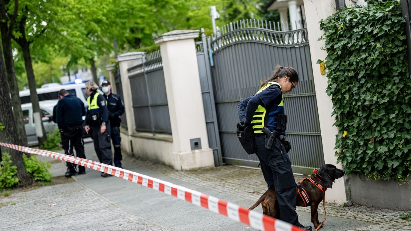 Beamten der Berliner Polizei suchen vor einem Haus an der Königsallee mit einem Spurensuchhund nach Spuren. Nach einer versuchten Brandstiftung an einem Auto auf einem Grundstück in Berlin-Grunewald ermittelt der polizeiliche Staatsschutz.