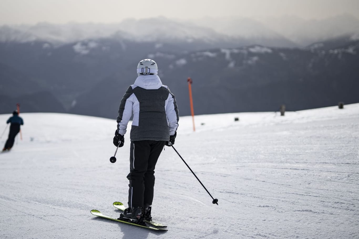 Ein Skifahrer in der Schweiz blickt auf den Saharastaub in der Luft: Ab Mittwoch wird es in Teilen des Landes deutlich kühler.