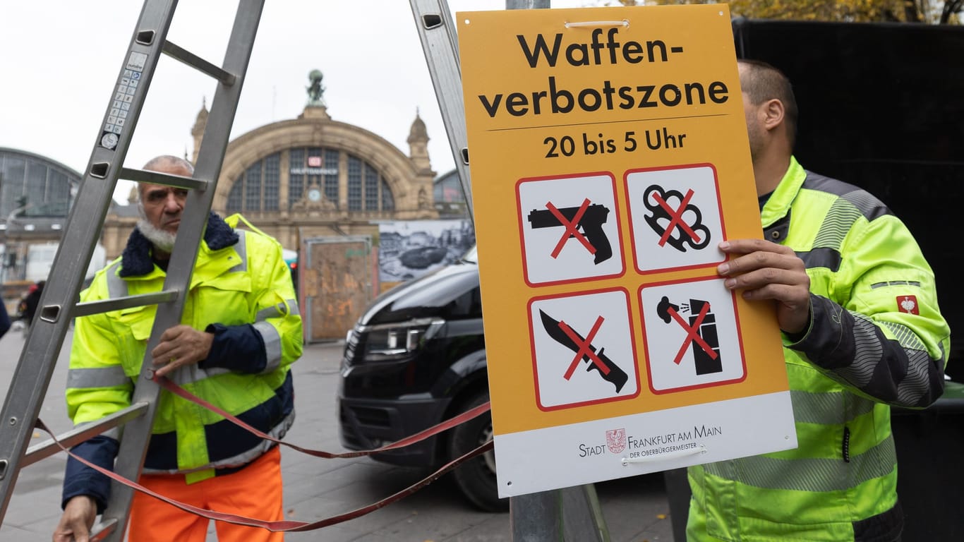 Zur Einführung der Waffenverbotszone im Frankfurter Bahnhofsviertel werden entsprechende Schilder montiert (Archivbild).