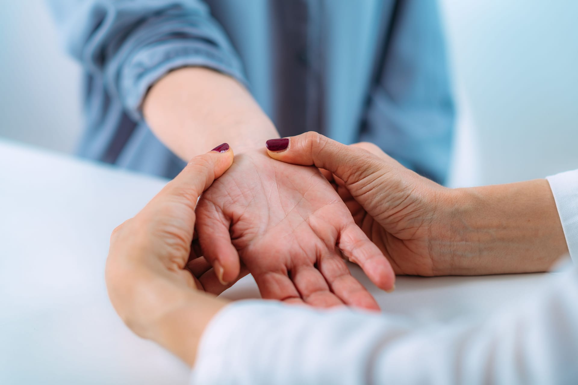 Eine Ärztin untersucht das Handgelenk einer Frau: Um bei einem Karpaltunnelsyndrom die Diagnose zu stellen, sind verschiedene Tests und Untersuchungen nötig.