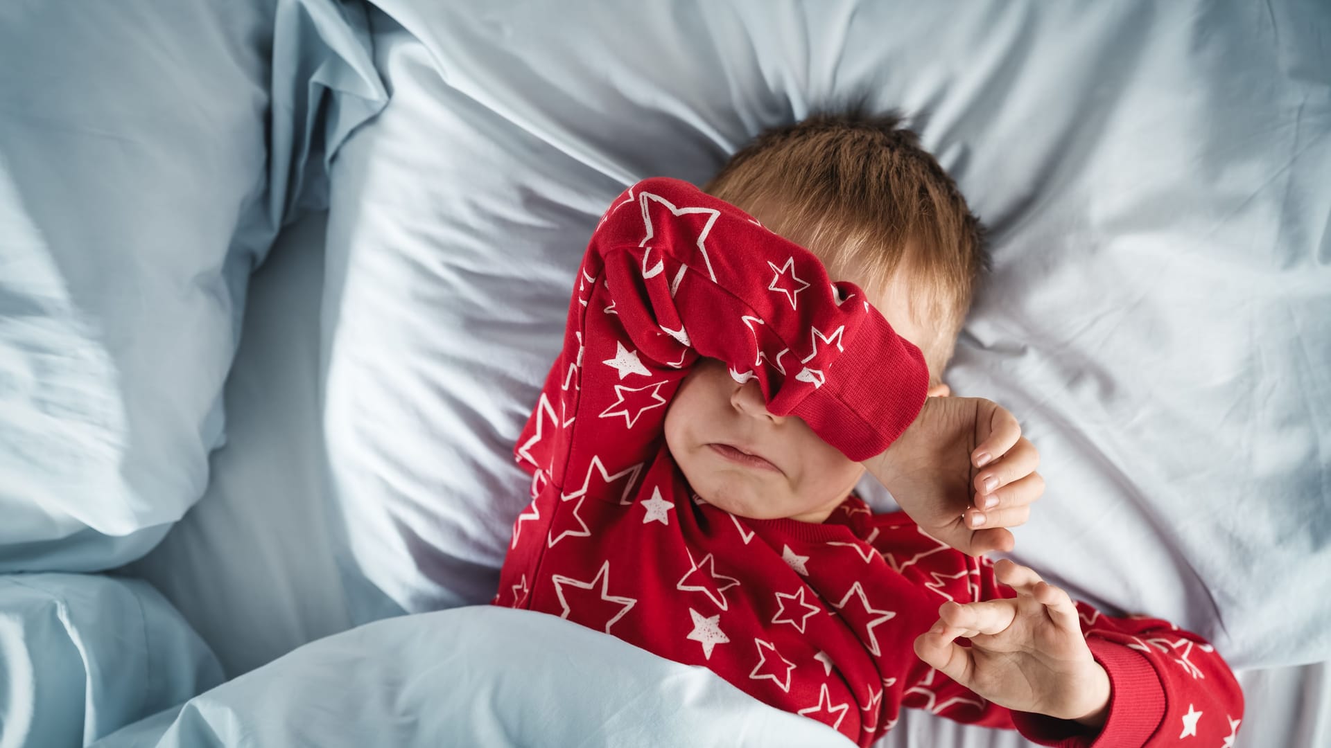 Kind liegt im Bett und kann nicht schlafen