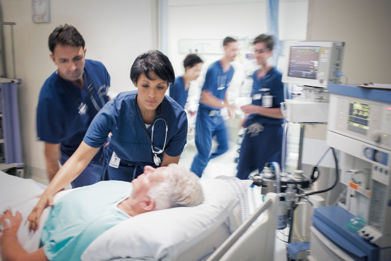 Ein Team ärztlicher Fachkräfte versorgt einen Patienten auf der Intensivstation.