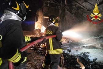 Feuerwehrleute löschen einen Brand in einem Tunnel: Ein deutscher Bierlaster soll auch an dem schweren Unfall beteiligt gewesen sein.