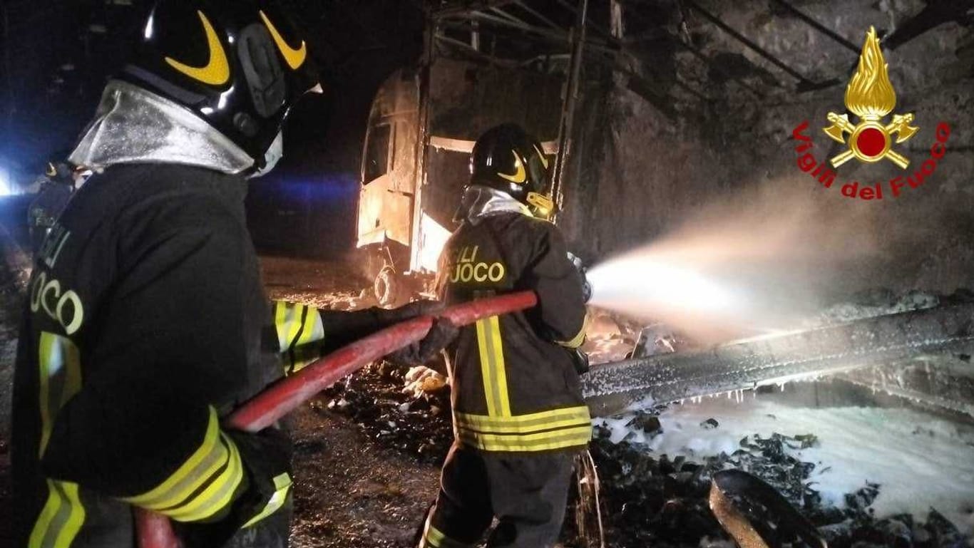 Feuerwehrleute löschen einen Brand in einem Tunnel: Ein deutscher Bierlaster soll auch an dem schweren Unfall beteiligt gewesen sein.