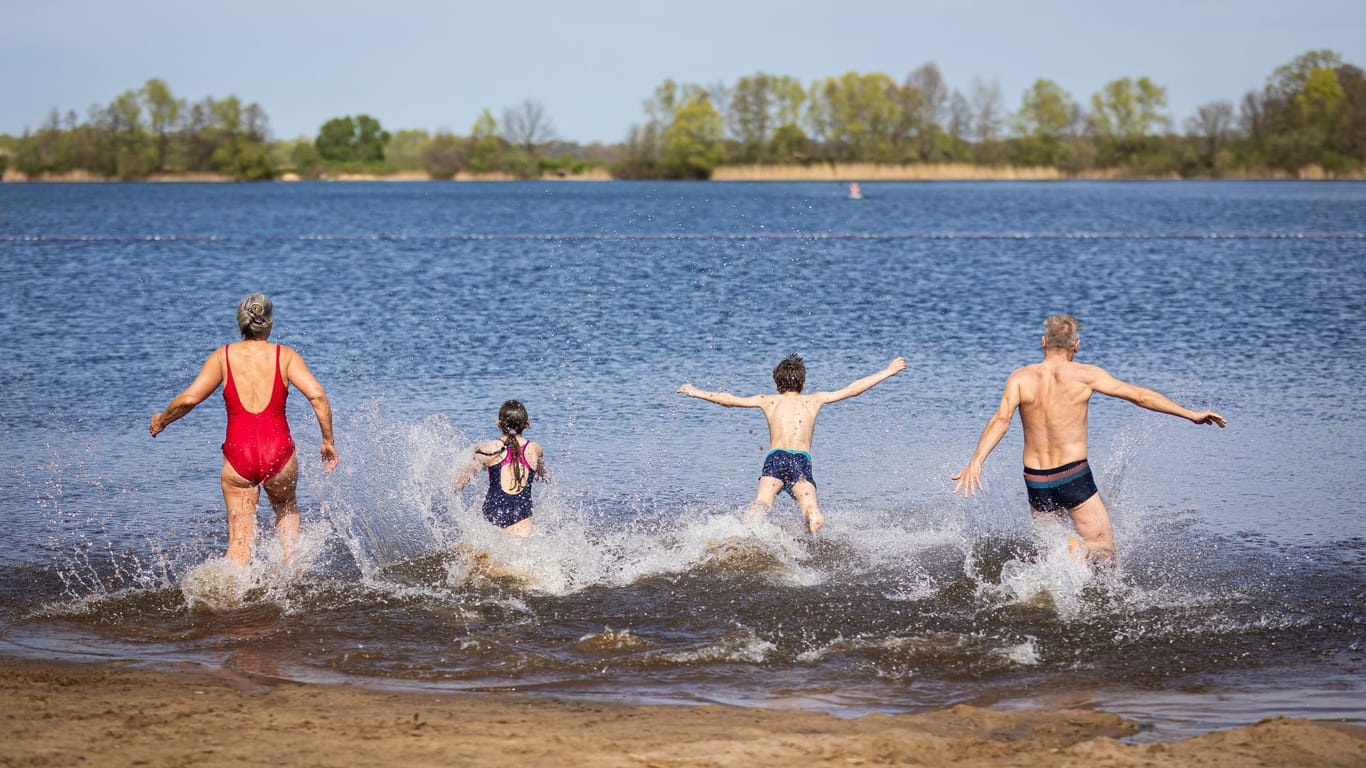 Isernhagen: Eine Familie läuft bei sonnigem Wetter in den Hufeisensee.