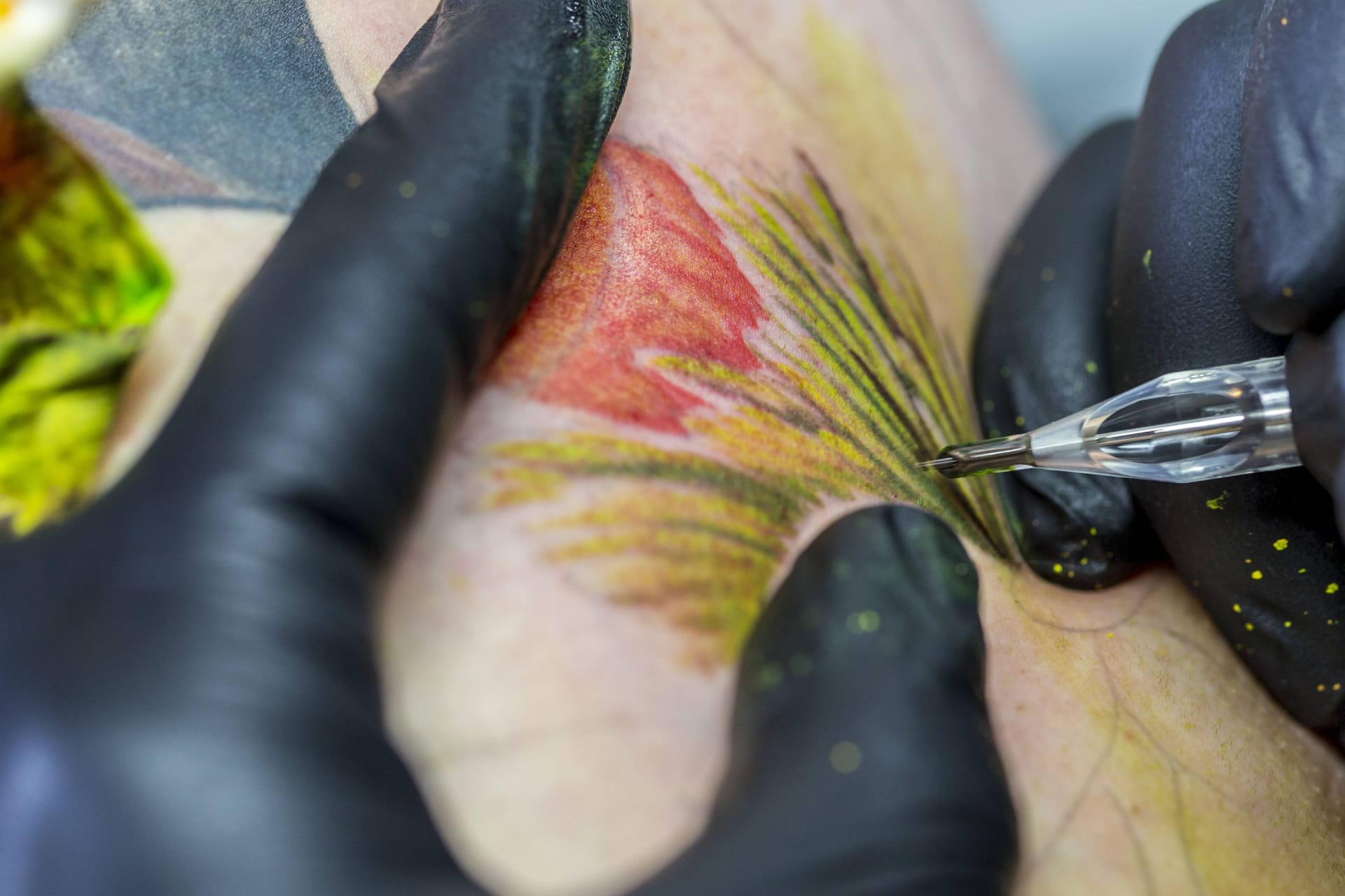 Tätowierer bei der Arbeit mit der Tätowiermaschine (Symbolbild): Das britische Gesundheitsamt warnt vor nicht lizenzierten Tattoostudios.