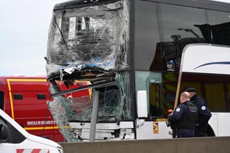 In Calais stehen französische Polizeibeamte neben dem beschädigten Bus.