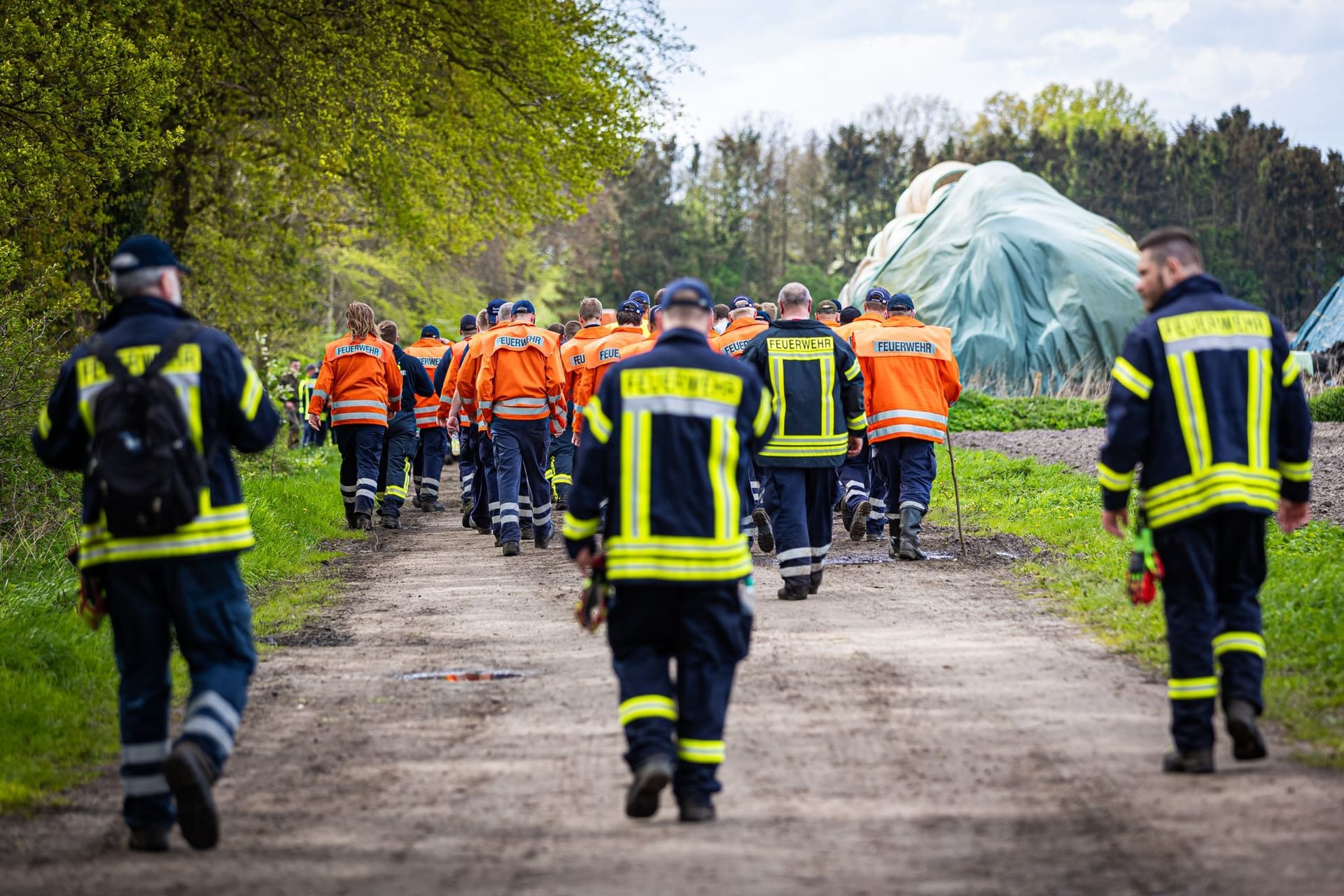 Einsatzkräfte der Feuerwehr gehen am Wochenende eine Straße im Landkreis Stade entlang. Mittlerweile ist der großflächige Einsatz beendet – die Suche nach Arian wurde eingestellt.